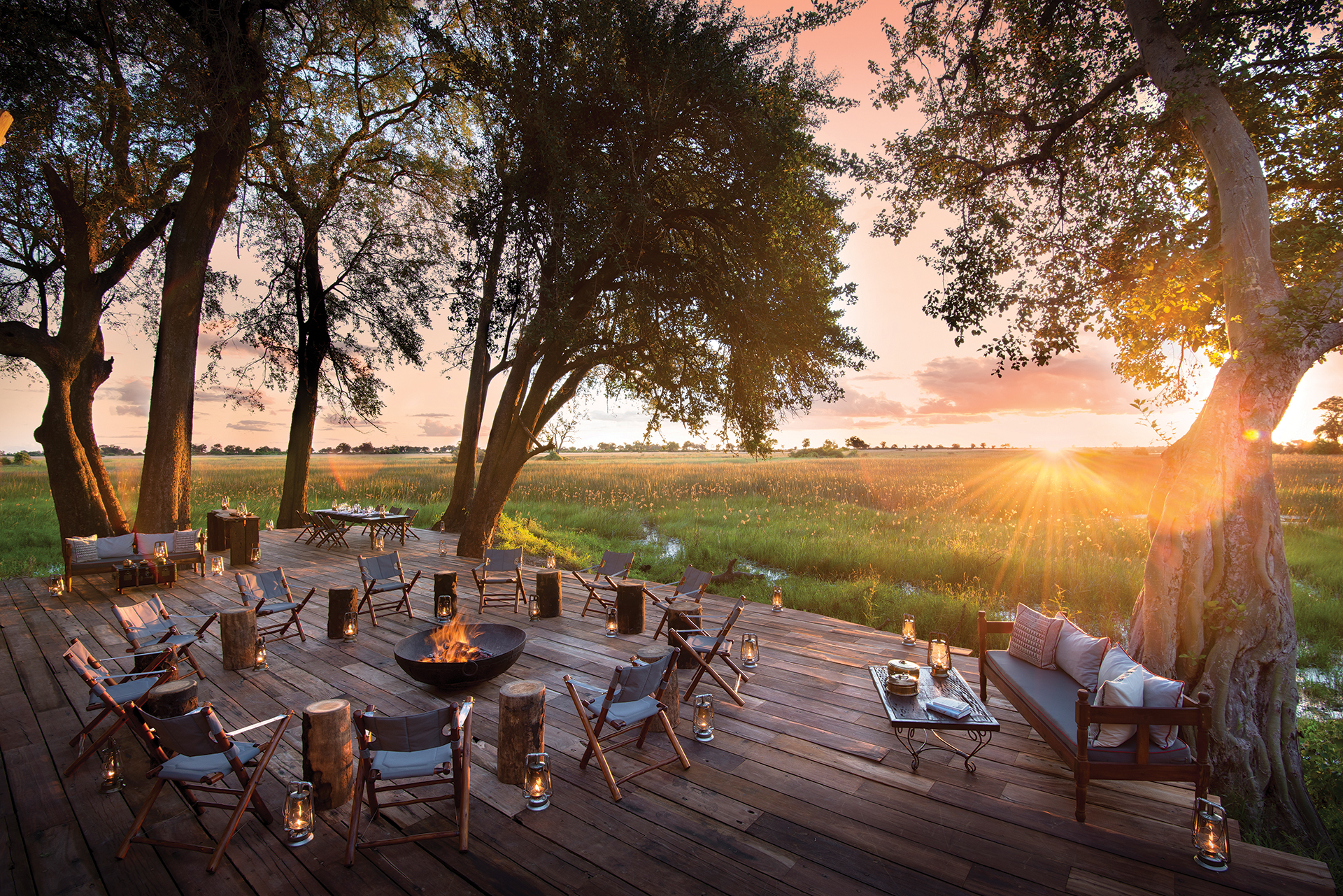 Outdoor seating deck at sunset at Duba Plains Camp