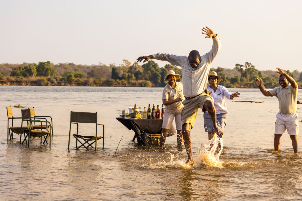 Great Plains Tembo Plains Camp Team dancing in the river